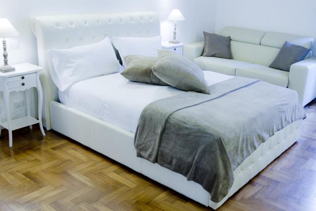 罗马里佩塔3号旅馆的客房内的一张带枕头的白色床和一张沙发