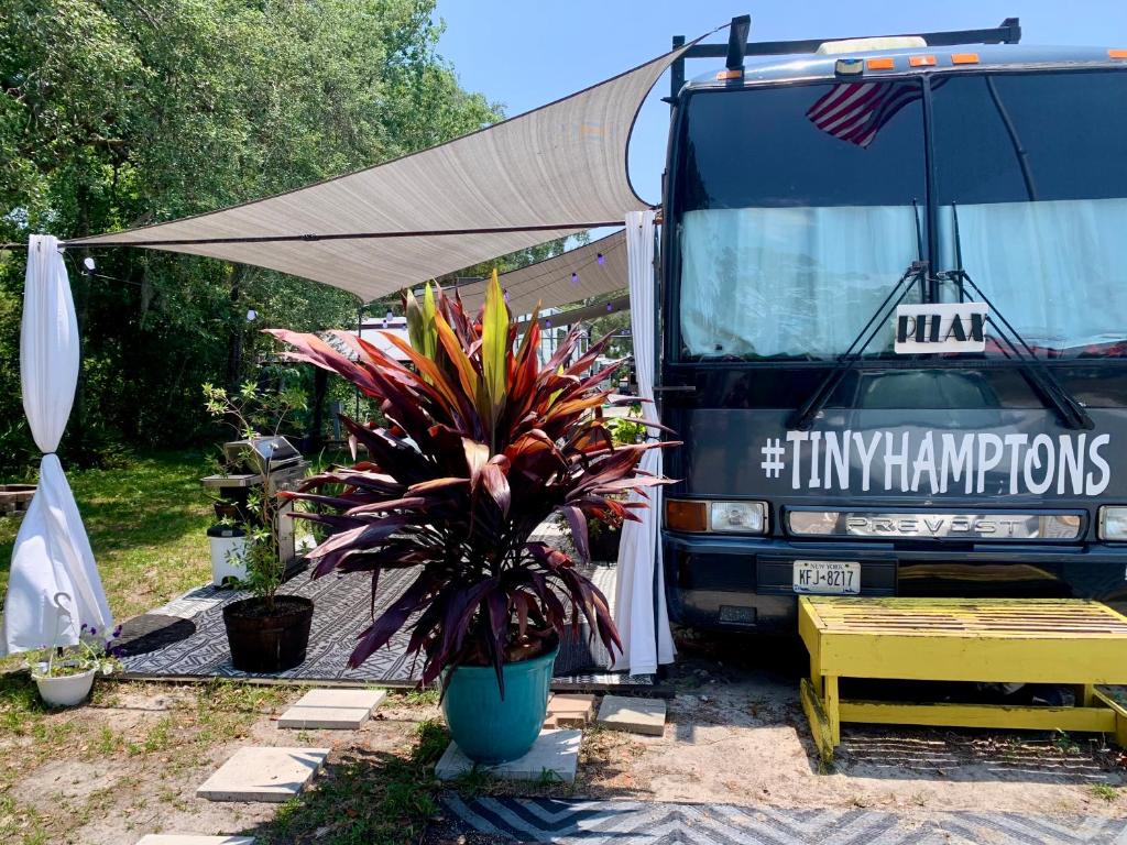 克莱蒙Unique tour bus conversion, Pet friendly, The Jitney的装有帐篷和盆栽的食品车