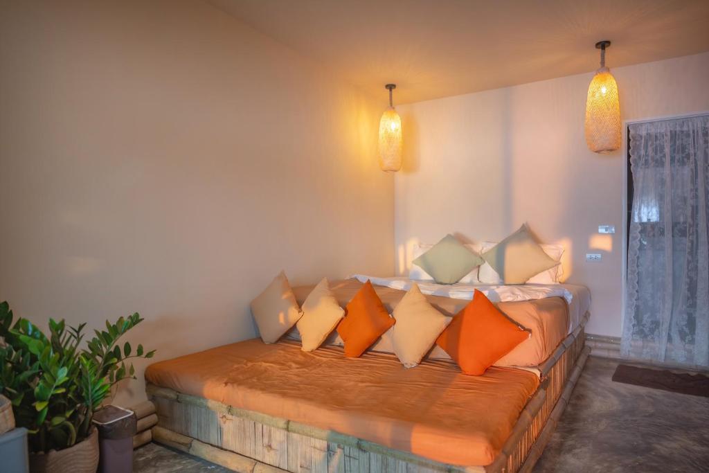 格兰岛Bamboo Beachfront Koh Larn的一间卧室配有带橙色和白色枕头的床