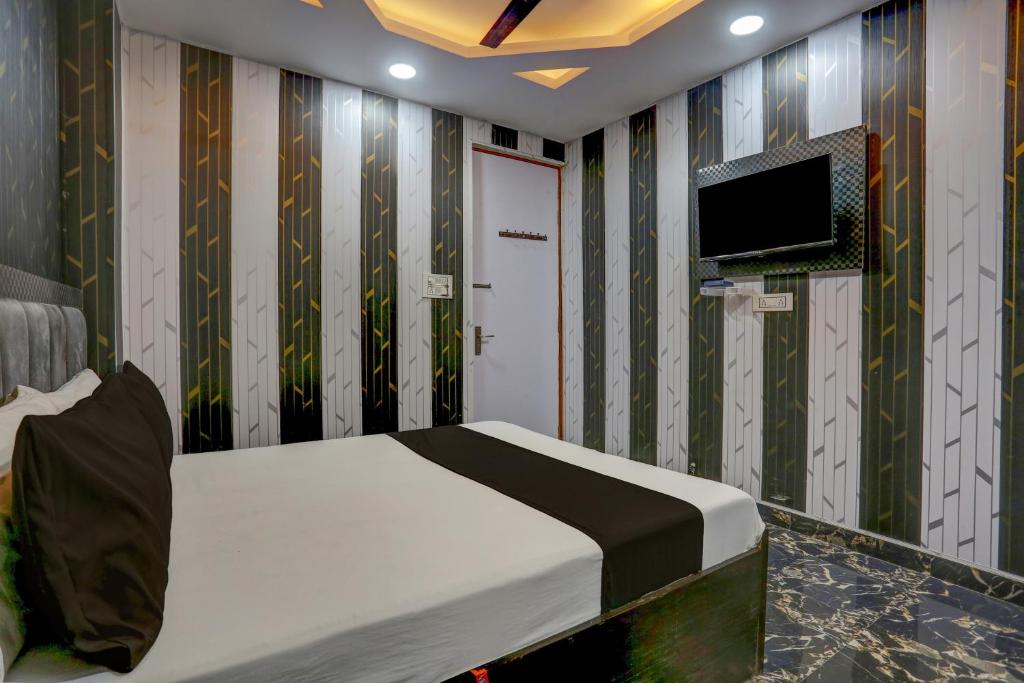 坎普尔OYO Flagship Shri Govindam palace的卧室配有一张床,墙上配有电视。