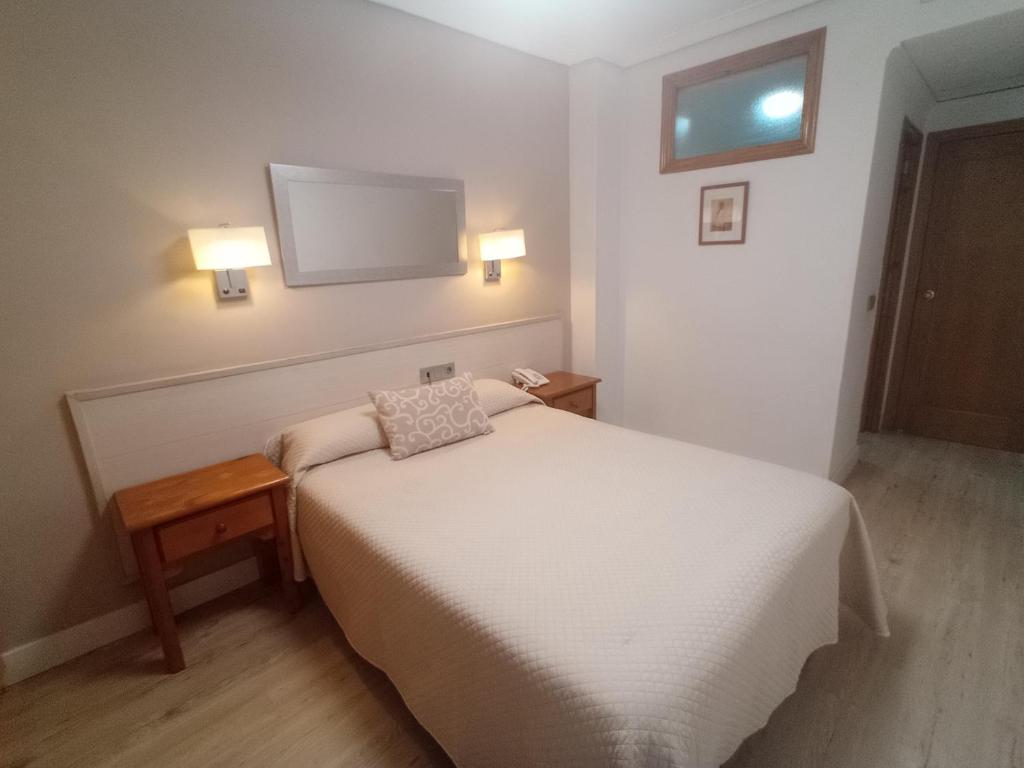 阿尔巴塞特诱惑旅馆的一间小卧室,配有白色的床和窗户