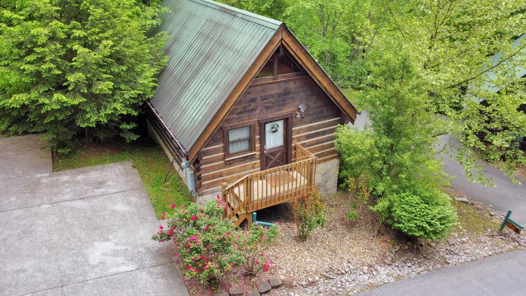 加特林堡Cozy Cabin! Hot Tub, King Bed, Fireplace, & Pool的小屋的顶部景色,设有长凳和鲜花