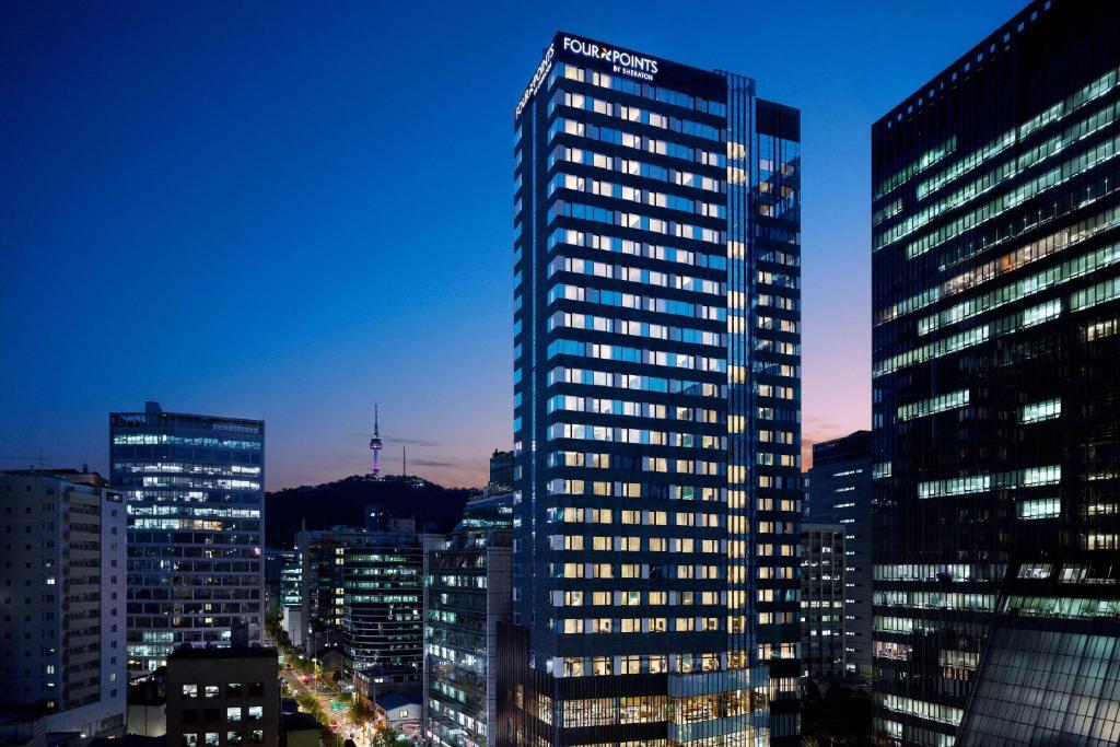 首尔Four Points by Sheraton Josun, Seoul Myeongdong的夜晚在城市的高楼