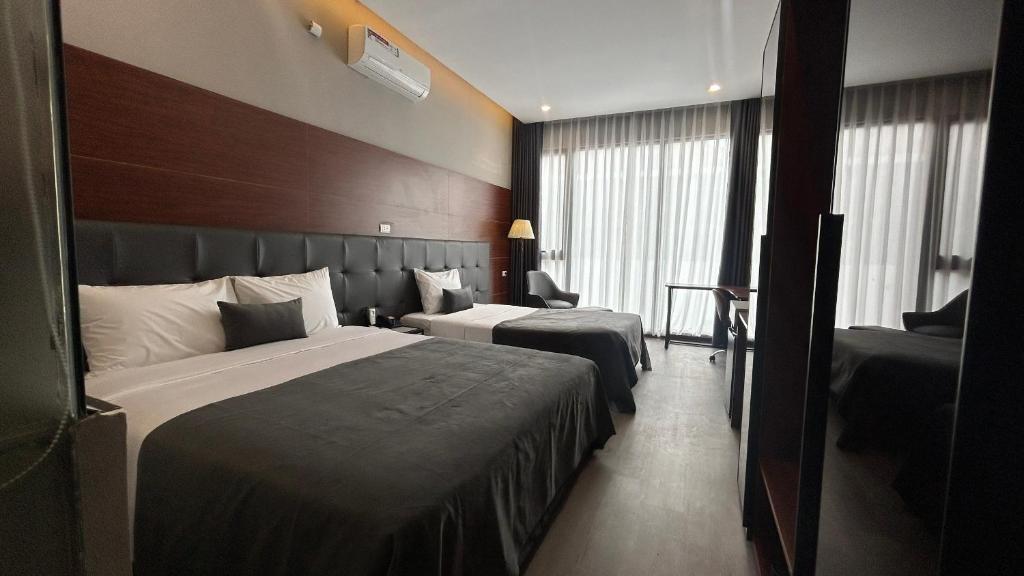 河内Mango Hotel - Ha Noi Railway station的酒店客房设有两张床和大窗户。