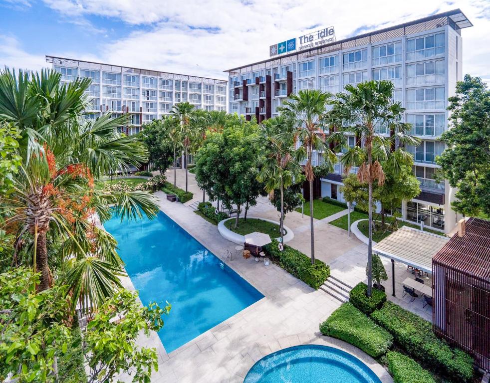 巴吞他尼The Idle Hotel and Residence - SHA Plus Certified的享有酒店空中景色,设有游泳池和棕榈树