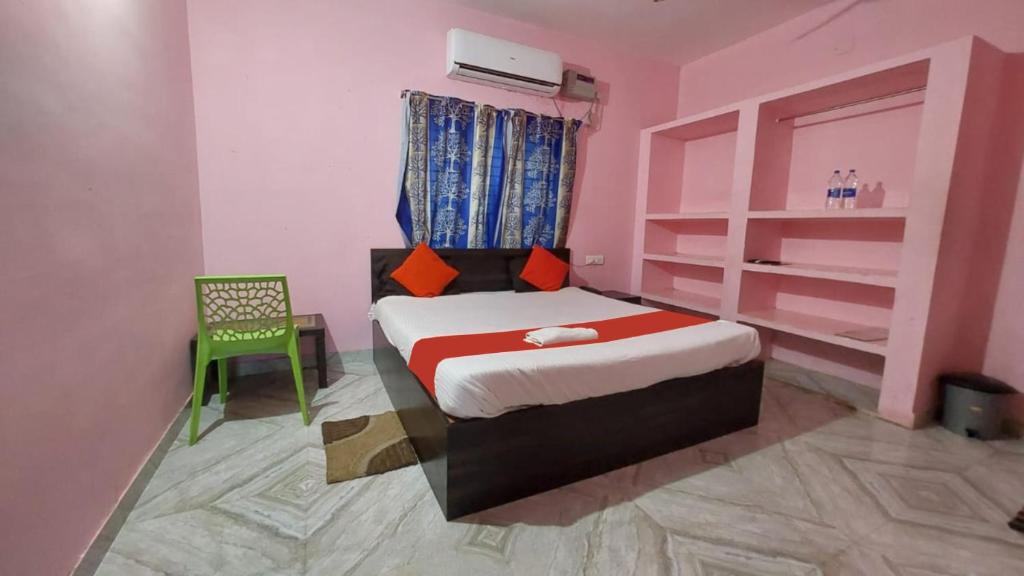 布巴内什瓦尔Goroomgo Madison Patia Bhubaneswar的一间小卧室,配有一张床和一把绿色椅子