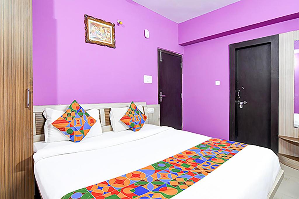 兰奇FabHotel Star Lotus的一间卧室设有紫色的墙壁和一张大床