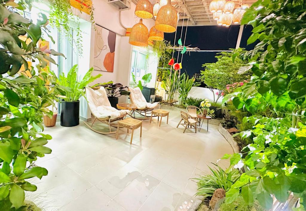 胡志明市Skyline Penthouse Greenery的一间布满植物和椅子的房间