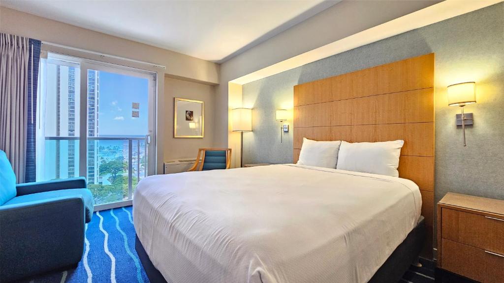 檀香山Ocean View Room at a resort的一间设有大床和窗户的酒店客房