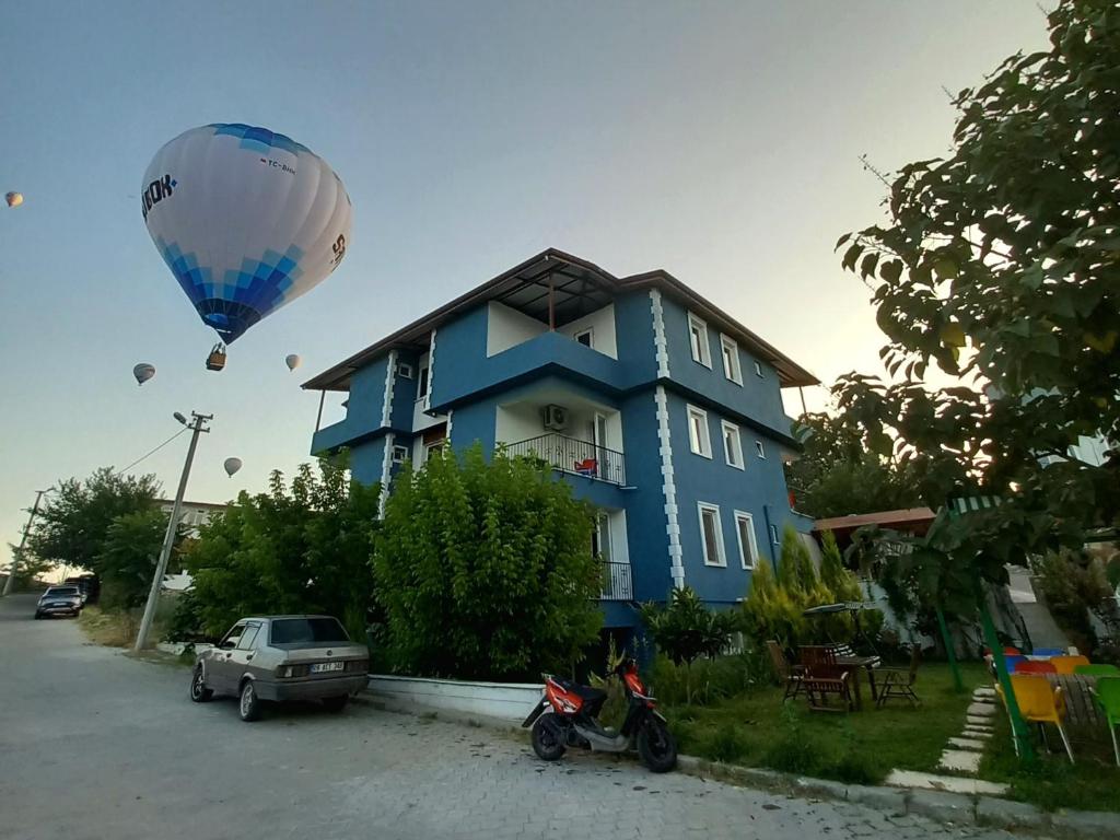 帕莫卡莱Paradise Boutique hotel的飞过蓝色房子的热气球