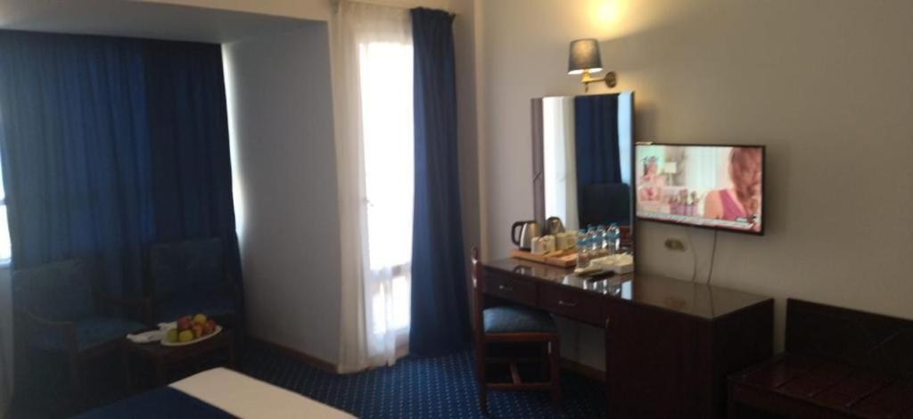 亚历山大Amon Alexandria的酒店客房设有书桌和窗户。