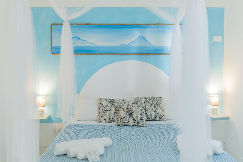 弗卡诺Holiday Eolie Village的蓝色客房的一张床位,配有两个枕头