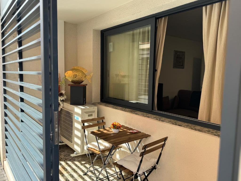 鲁维Apartamento Centro的阳台配有桌椅和窗户。