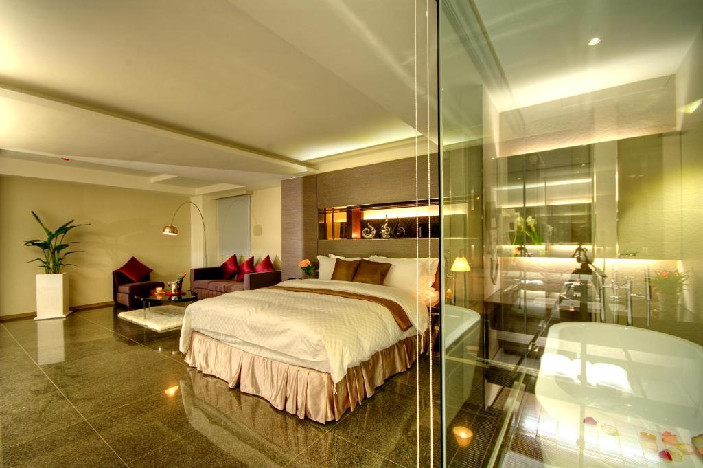 罗东镇木棉道 美学商旅的一间卧室设有一张床和玻璃墙