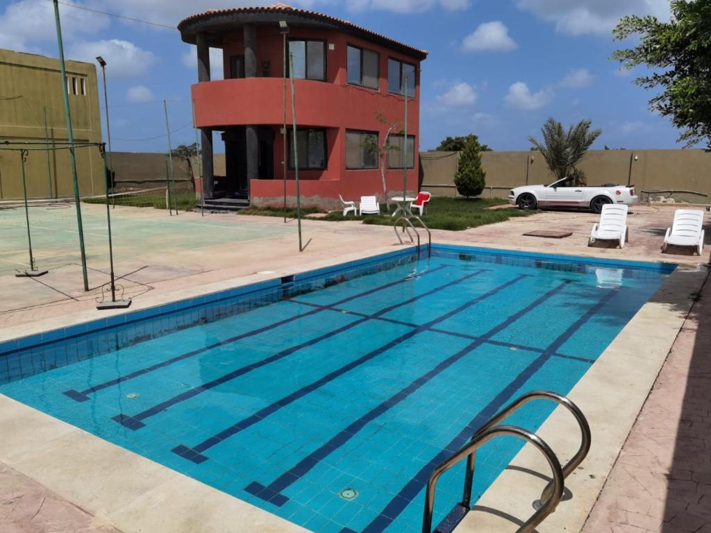 伯格埃拉伯Villa Mostafa Sadek, Swimming pool, Tennis & Squash - Borg ElArab Airport Alexandria的大楼前的游泳池