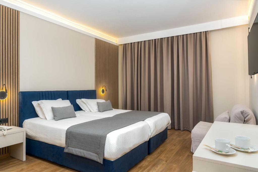 扎金索斯镇帕拉提诺酒店的酒店客房设有一张大床和一张桌子。
