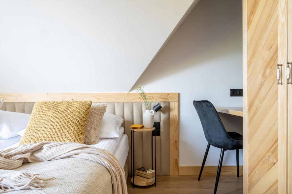考斯赛力克Aparteo Domek na 102 - Jeleń i Loft的一间卧室配有一张床、一张桌子和一把椅子
