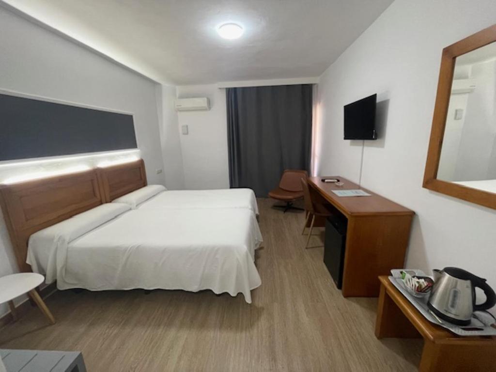 梅利利亚安佛拉酒店的配有一张床和一张书桌的酒店客房