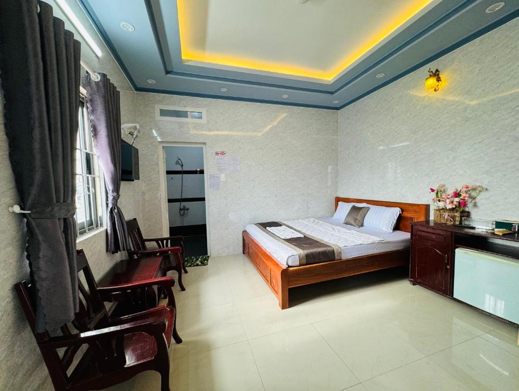 芹苴PHÚ PHƯƠNG NAM HOTEL的卧室配有一张床和一张桌子及椅子