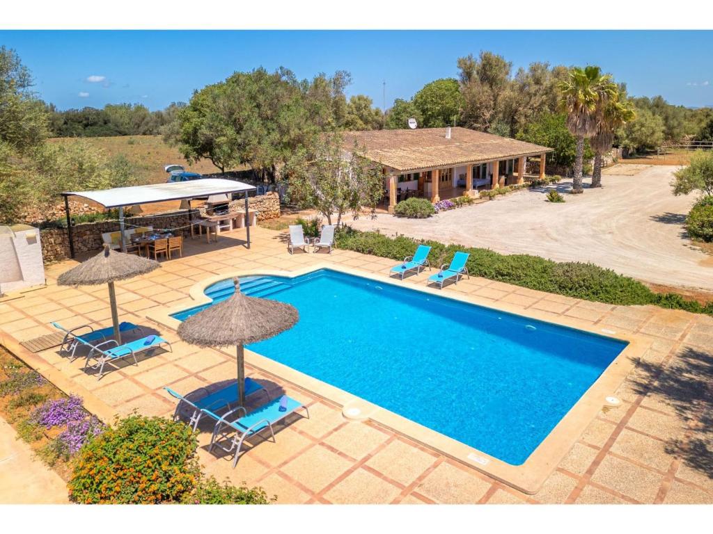 费拉尼特斯Holiday Home Can Soler - FEL125 by Interhome的享有带椅子和遮阳伞的游泳池的上方景色