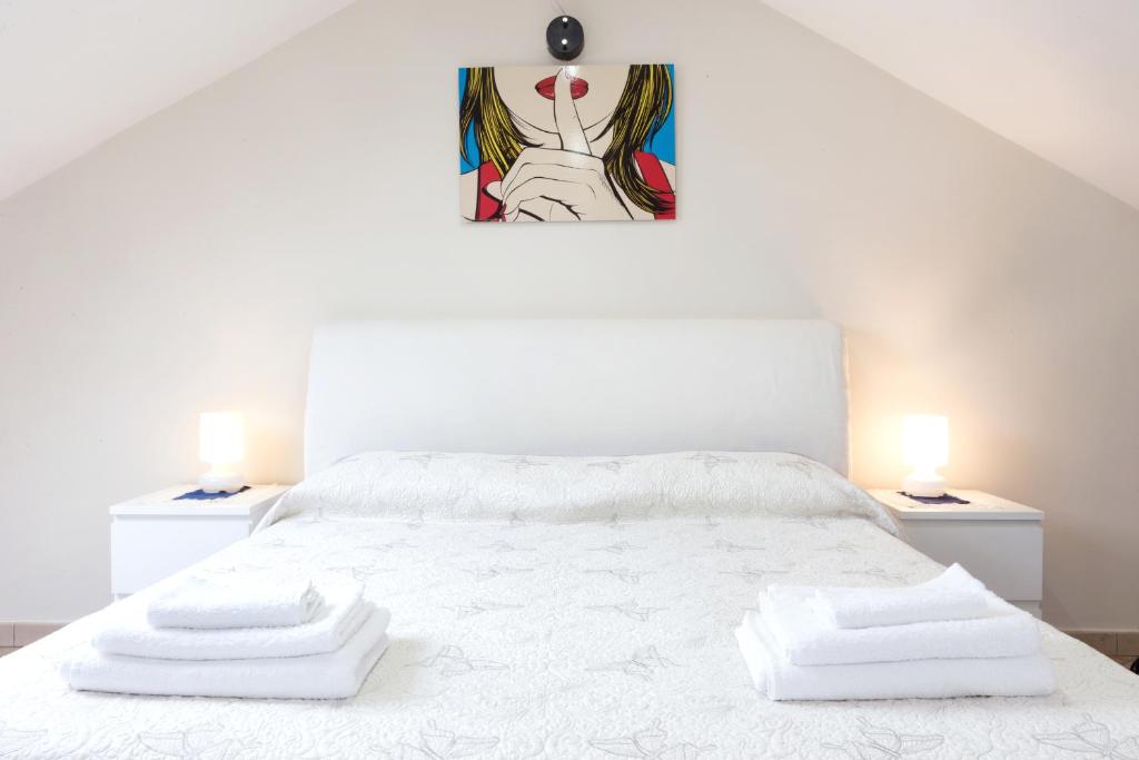 维纳利亚瑞勒A Pochi Passi的卧室配有带两盏灯的白色床