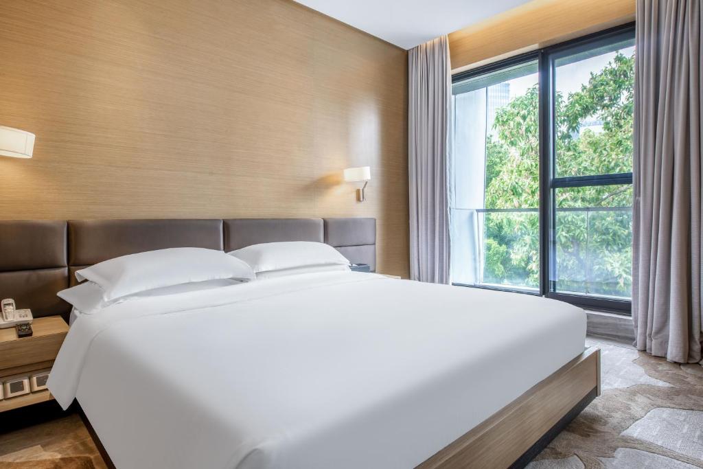 深圳深圳半山壹棠服务公寓的一张大白色的床,位于一个设有大窗户的房间