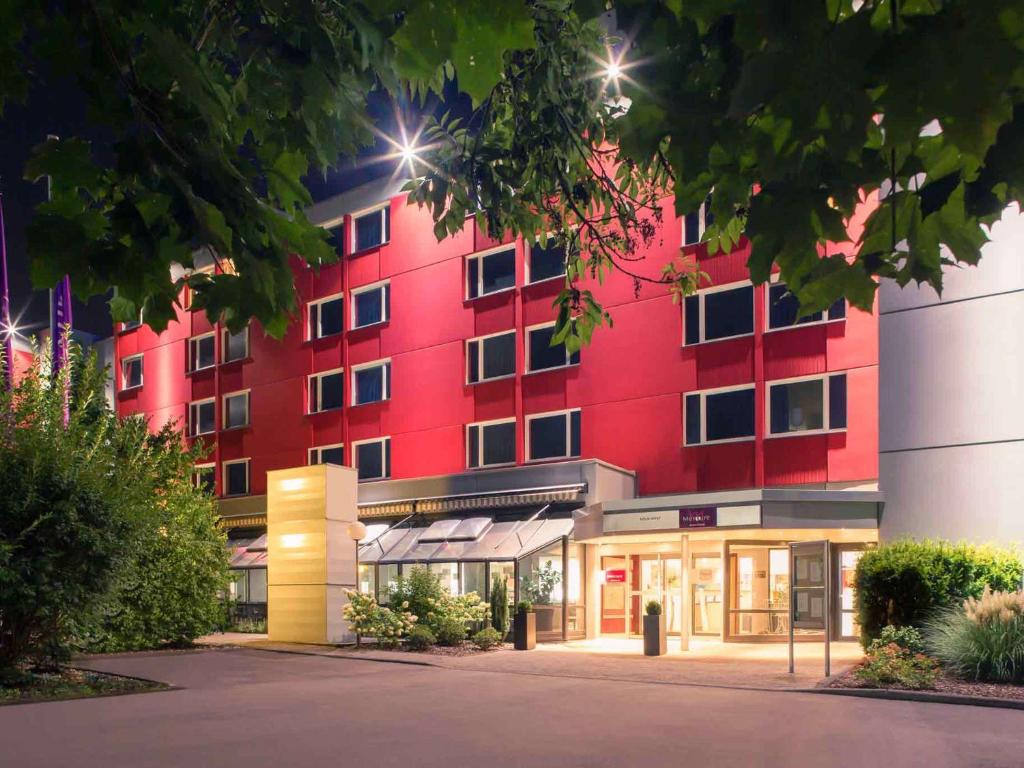 科隆科隆西美居酒店的前面有一间商店的红色建筑
