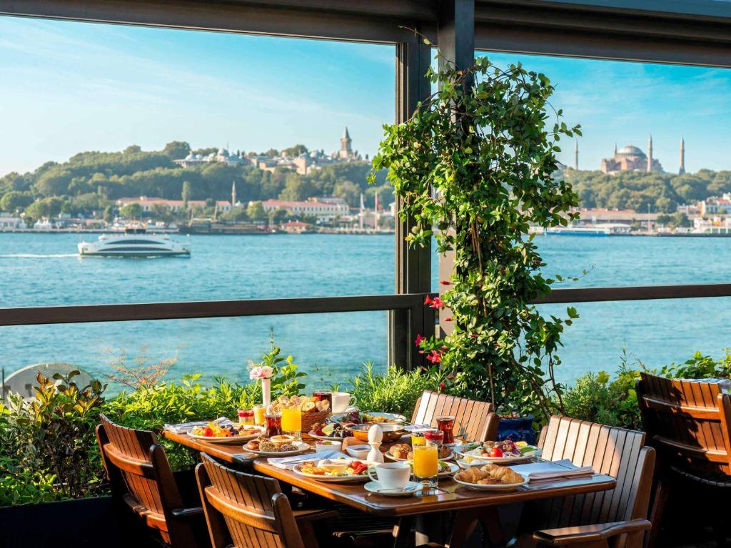 伊斯坦布尔诺富特伊斯坦布尔博斯普鲁斯酒店 的一张带食物的桌子,享有水景