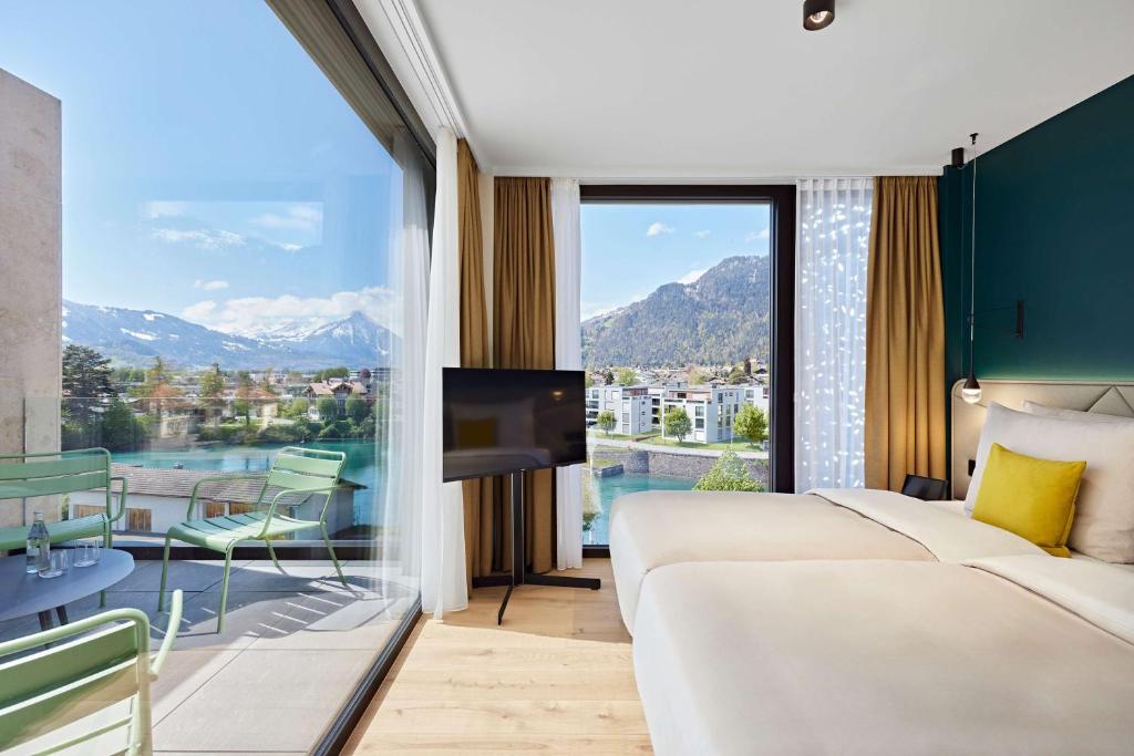 因特拉肯Essential by Dorint Interlaken - New Opening的酒店客房设有一张床和一个大窗户