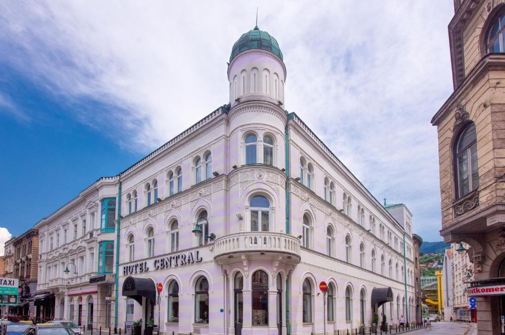 萨拉热窝Hotel Central Sarajevo的一座白色的建筑,上面有一座塔