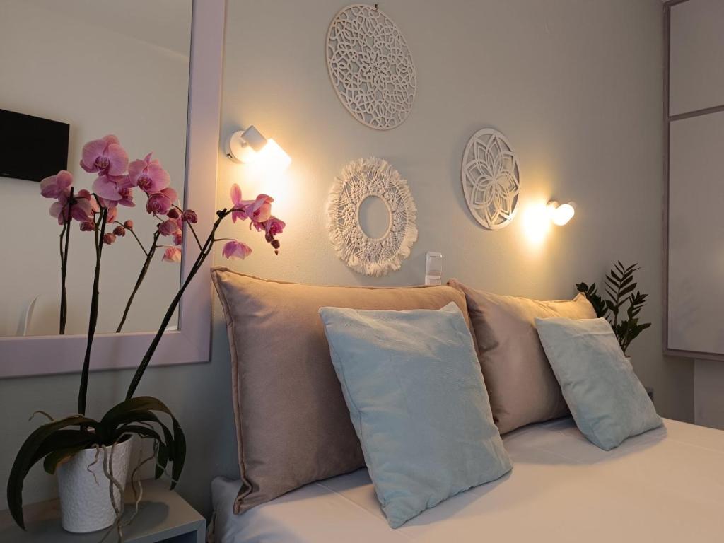 阿查拉维Philippos Apartments的一间卧室配有带枕头的床和鲜花花瓶