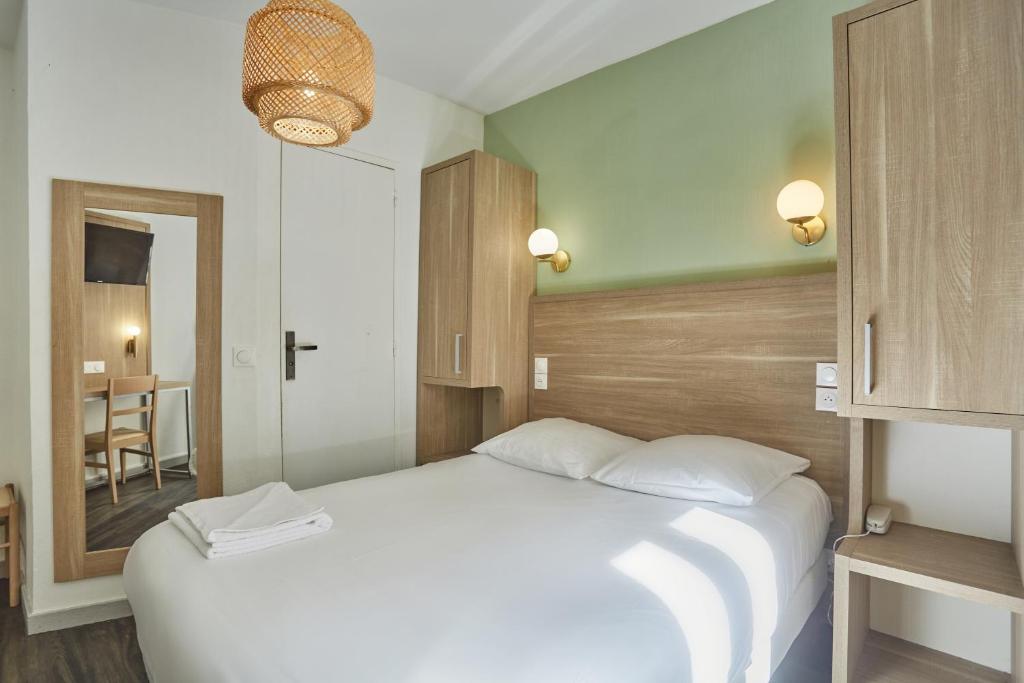 巴黎巴黎北站梅尔里勒酒店的卧室配有一张白色大床和镜子
