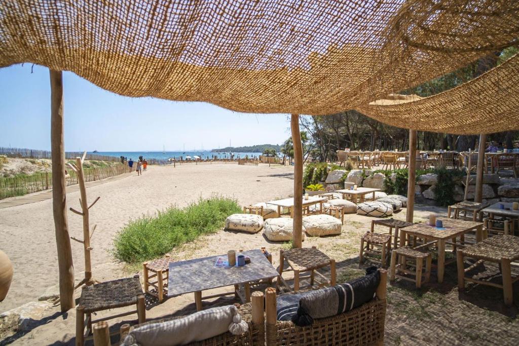 耶尔Le Domaine de la mer - Beach hotel Nature&Authenticité Hyères的沙滩上带桌椅的海滩