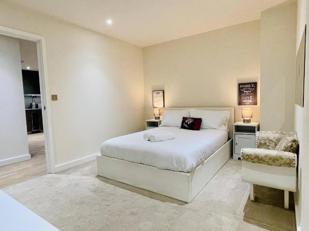 亨顿Jenny's Place的卧室配有白色的床和椅子