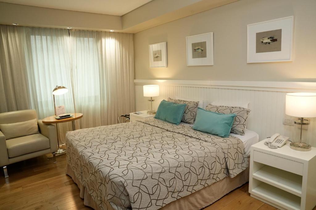 布宜诺斯艾利斯苏普拉大都会酒店的配有一张床和一把椅子的酒店客房