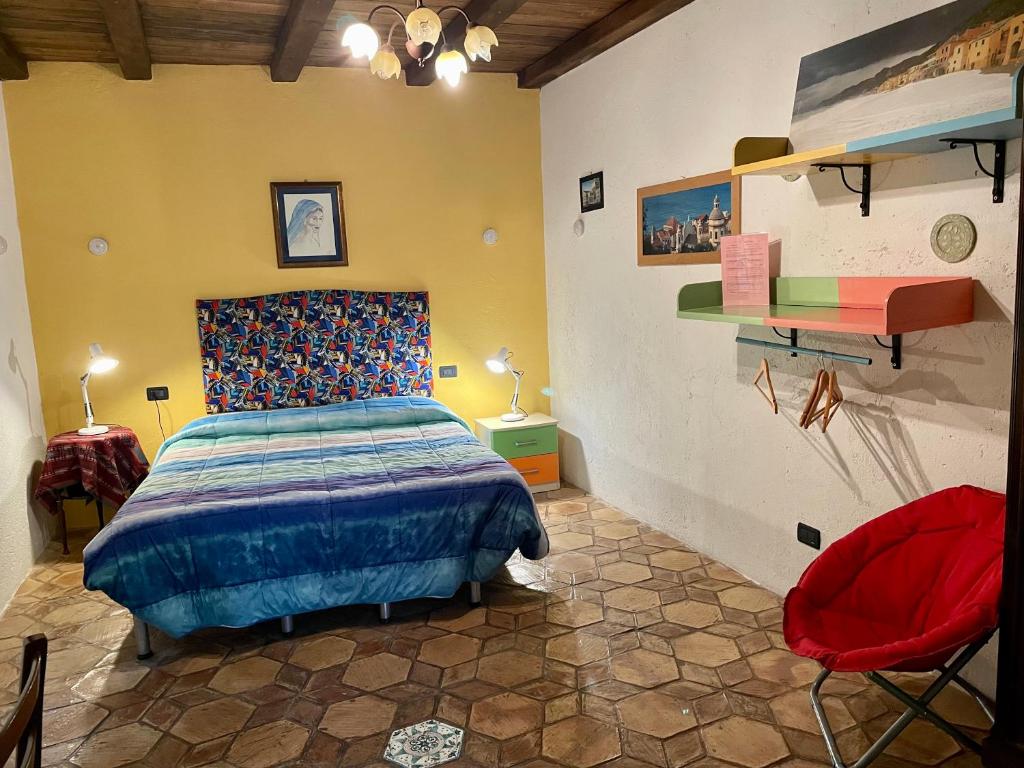 Vezzi PortioLe Petit Chateau的一间卧室配有一张床和一张红色椅子