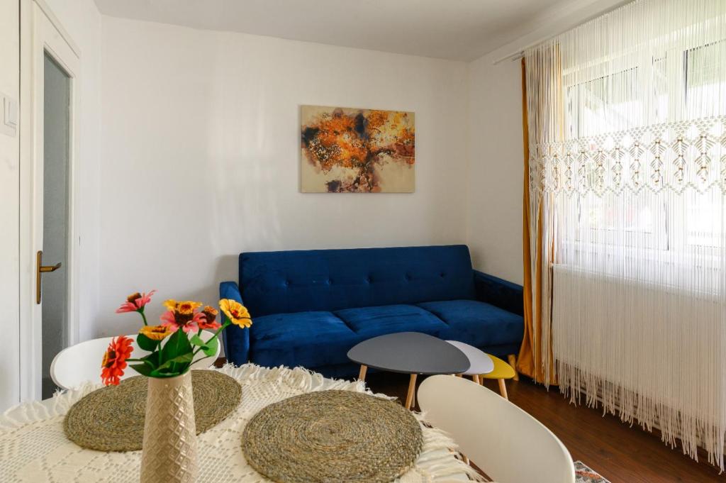比斯特里察Apartament Corina cu parcare的客厅配有蓝色的沙发和桌子