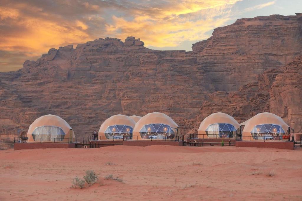 瓦迪拉姆Faisal Wadi Rum camp的一群在沙漠中的圆顶,靠近一个山