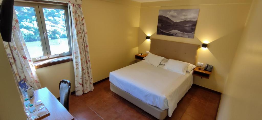 福斯图阿卡萨都图阿酒店的卧室配有白色的床和窗户。