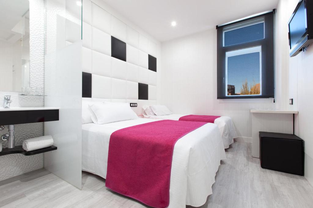 富恩拉夫拉达Hoteles Urbanos N Avenida de España的白色卧室配有一张带红色毯子的大床