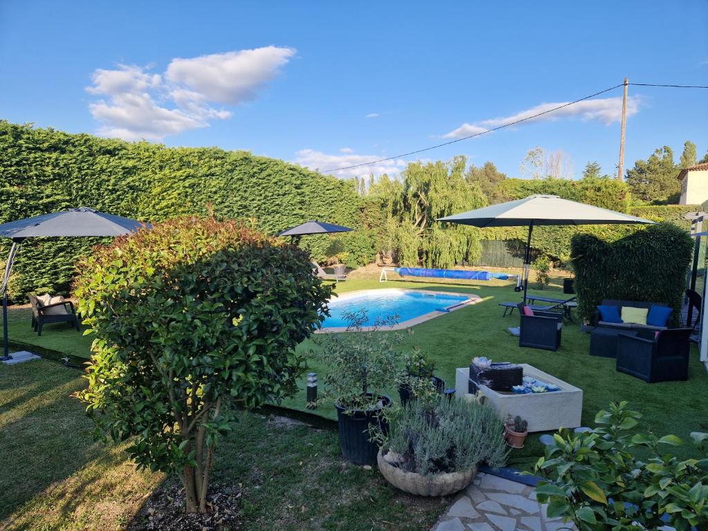 卡布列斯埃塔普普罗文卡勒酒店的后院设有带遮阳伞和植物的游泳池