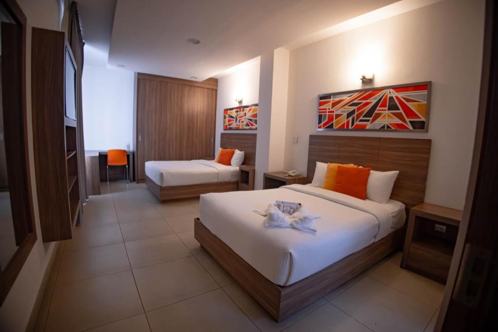 杜兰戈Hotel Villa Express Durango的酒店客房,设有两张床和一张沙发