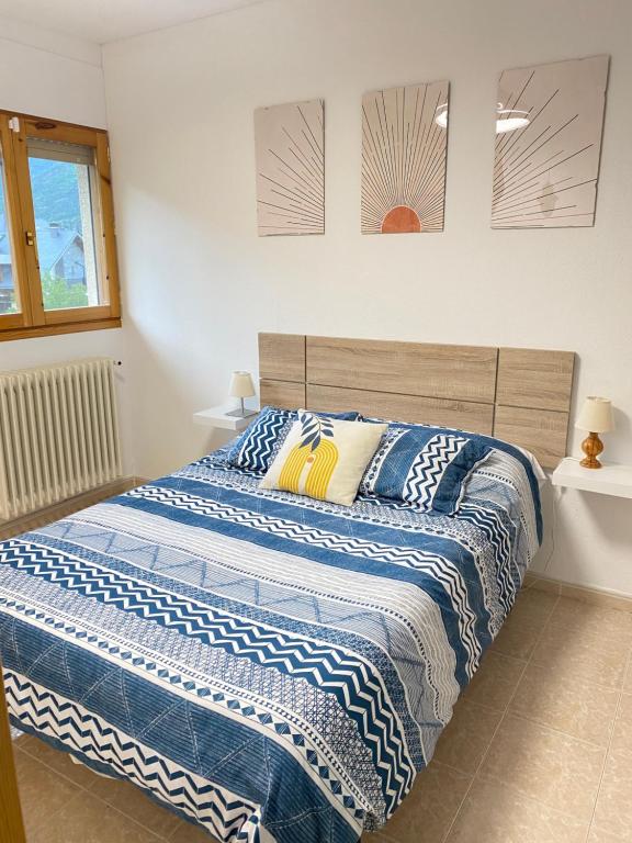 毕斯卡斯Apartamento Espert Biescas的一间卧室配有蓝色和白色床单