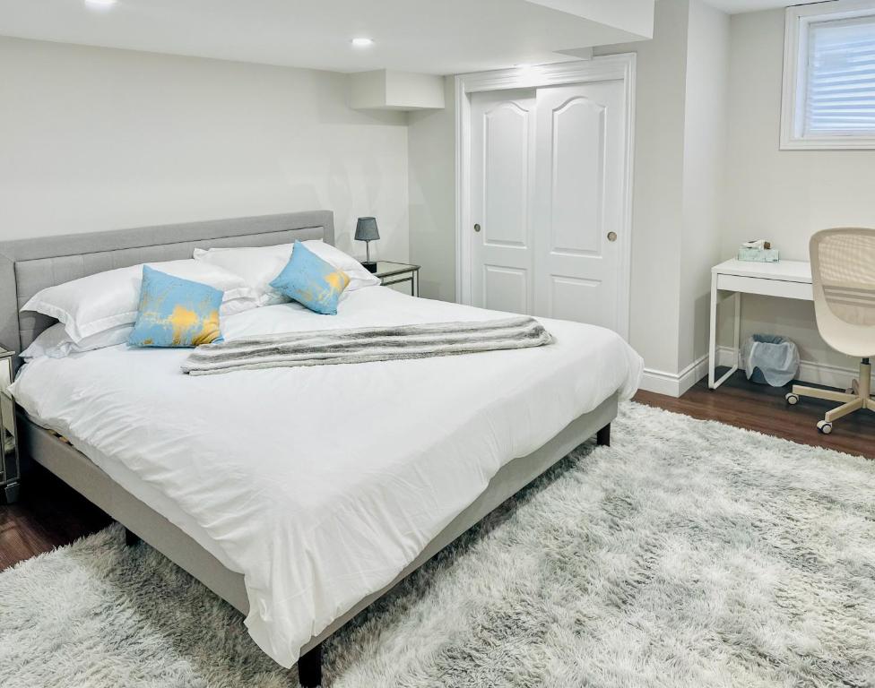 米西索加Spacious 2 Bedroom 1 bath Mississauga Basement Apartment的卧室配有带蓝色枕头的大型白色床