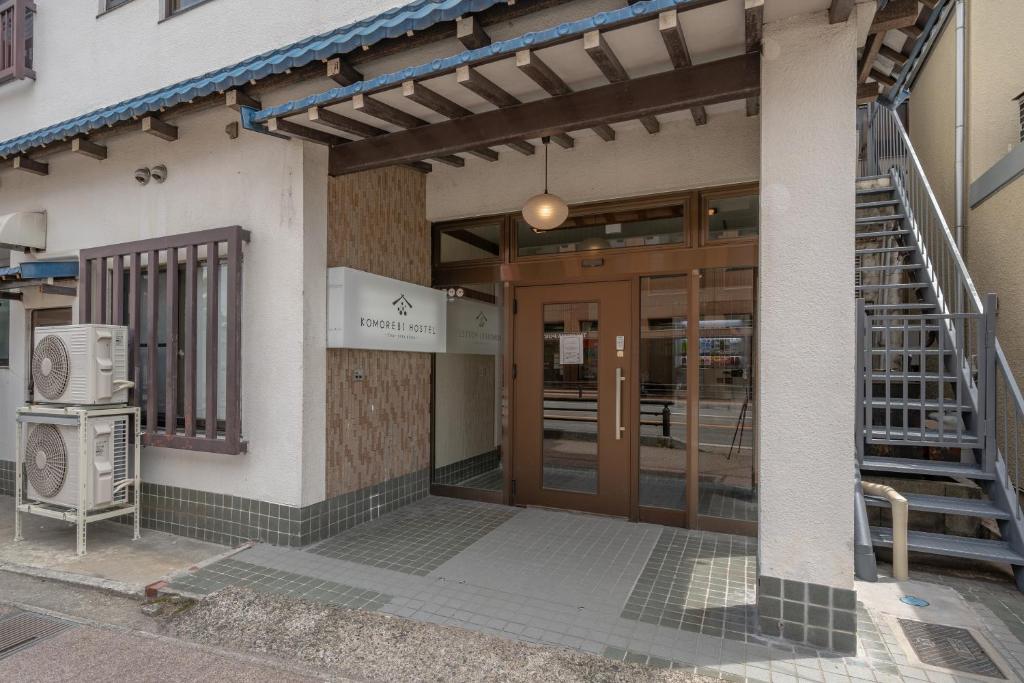 高山KOMOREBI HOSTEL-your cozy place-的通往大楼的入口,设有门和楼梯