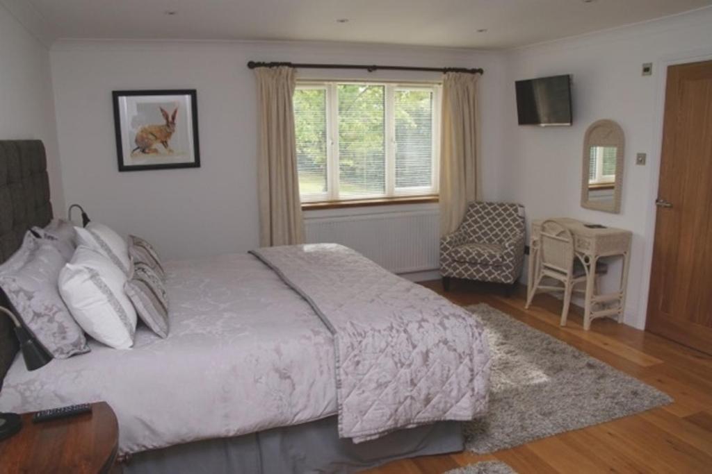 埃文河畔布拉德福樱桃树旅馆的一间卧室设有一张床、一个窗口和一把椅子