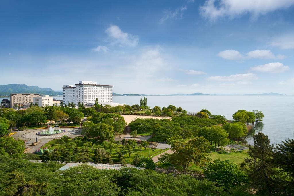 长滨市Grand Mercure Lake Biwa Resort & Spa的一座有树木和大片水体的公园