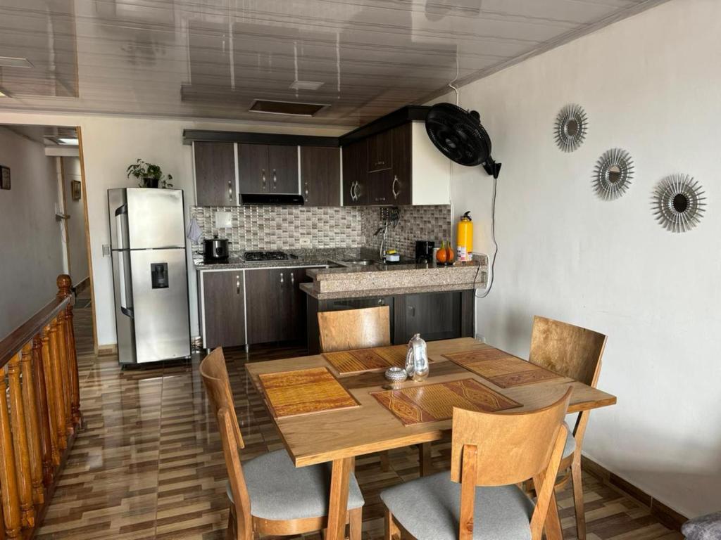 亚美尼亚Alojamiento Villasofia的厨房配有木桌和冰箱。