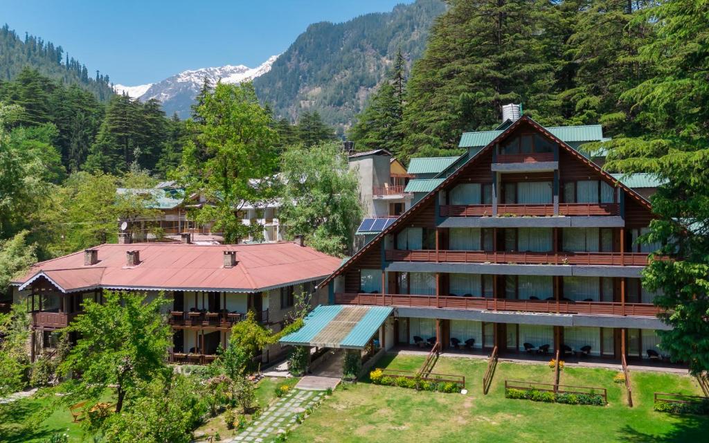 马拉里Bedzzz Xclusiv Baikunth, Manali By Leisure Hotels - 650 meters from Hidimba Devi Temple的享有高山上一座大建筑的空中景致