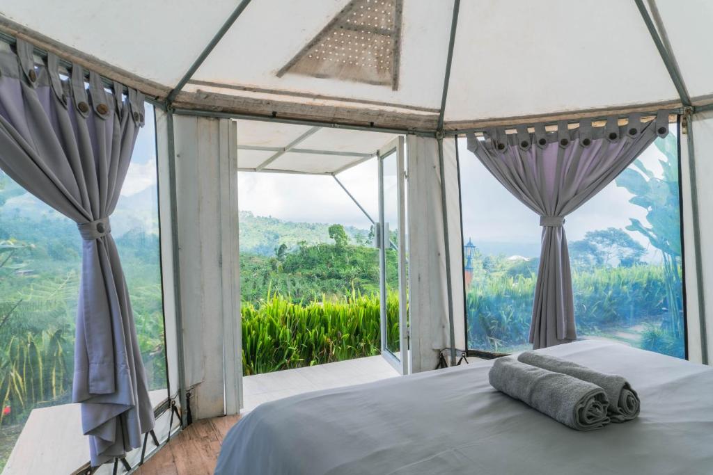 姆杜克Alam Kita Glamping & Plantation的一间卧室设有一张床和一个大窗户